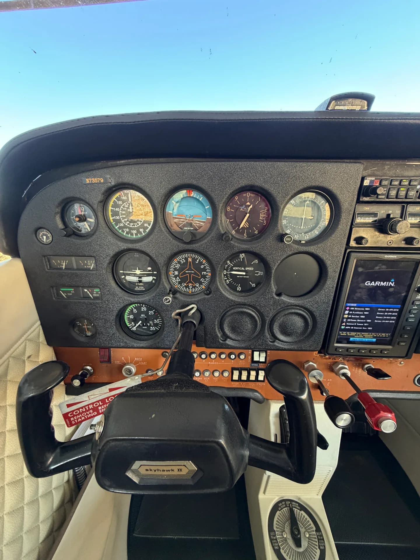 Cessna 172M cockpit instrument panel with six-pack gauges and Garmin 696