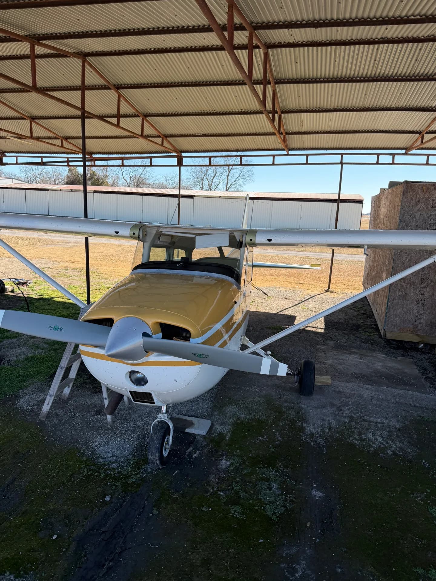 Cessna 172M head-on nose view showing prop and cowling under hangar