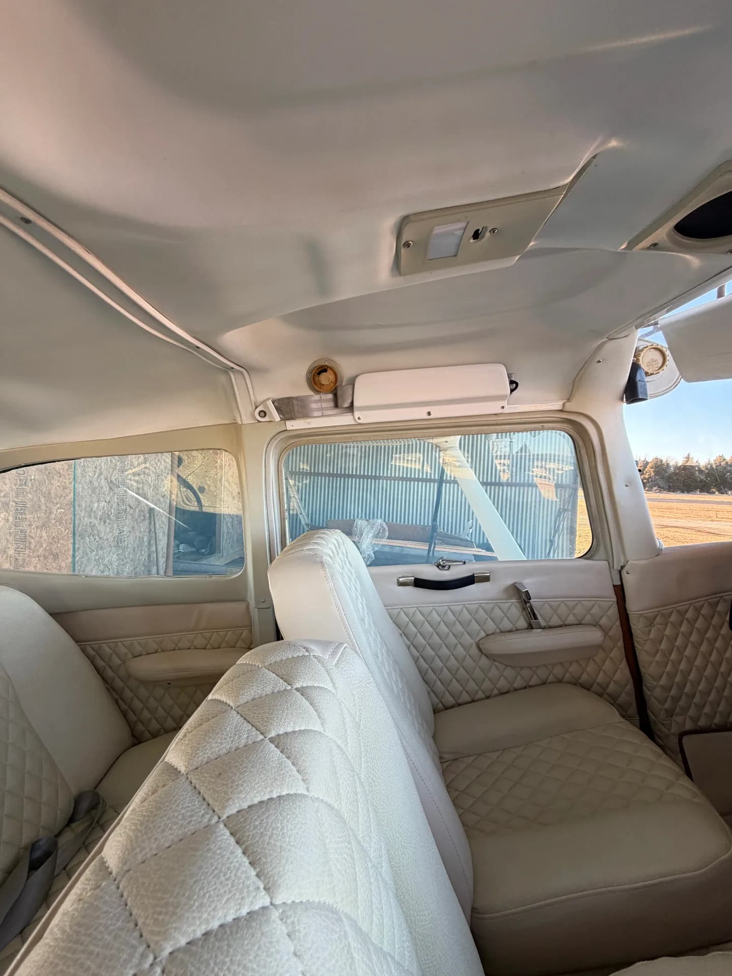 Cessna 172M cabin looking up at headliner, air vents, and rear windows